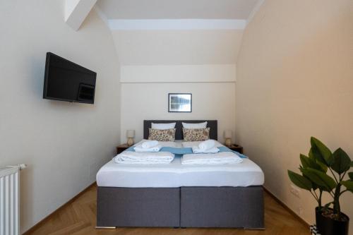 a bedroom with a bed with a tv on the wall at Vienna Stay Apartments Schönbrunn in Vienna