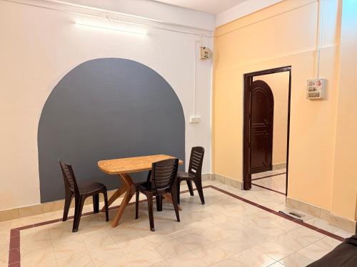 a dining room with a wooden table and chairs at Ghar Homestay in Silchar