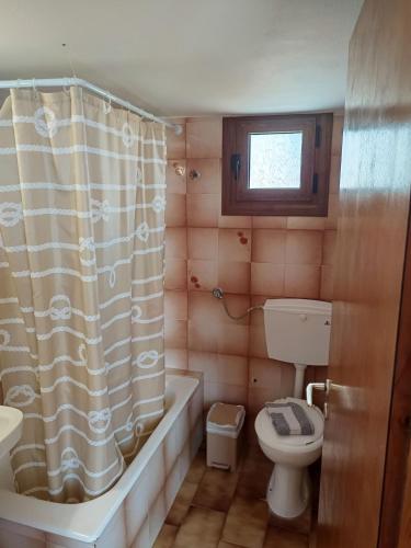 a bathroom with a tub and a toilet and a sink at ANATOLI ROOMS SERIFOs in Serifos Chora
