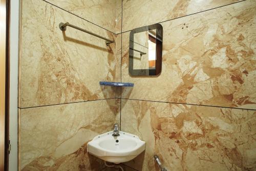a bathroom with a sink and a mirror at PS Luxury Hotel in Baharampur