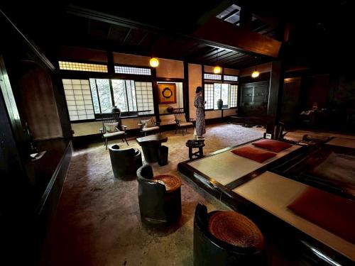 a man standing in a room with a room with tables at Wanosato in Takayama