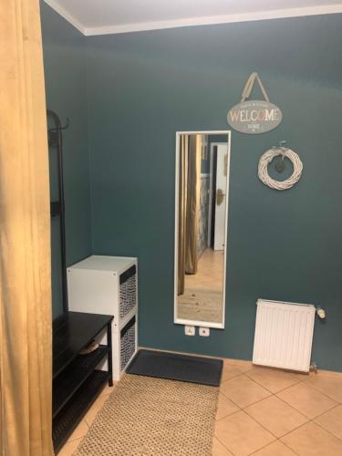 a mirror on a blue wall in a room at Apartament dwupokojowy in Gollnow