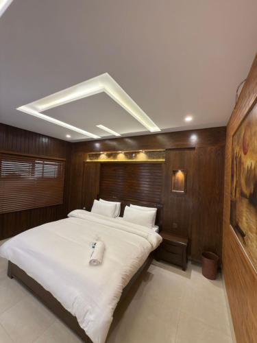 a large bedroom with a large bed with white sheets at Go Glam Hotel Murree in Murree