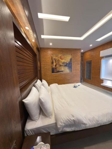 a bedroom with a large bed with white pillows at Go Glam Hotel Murree in Murree