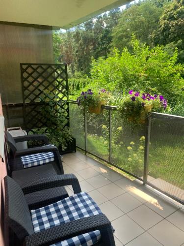 a porch with chairs and a balcony with flowers at Apartament dwupokojowy in Gollnow