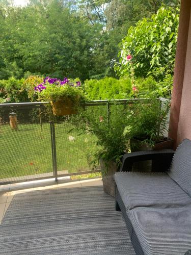 a porch with a couch and flowers on a balcony at Apartament dwupokojowy in Gollnow