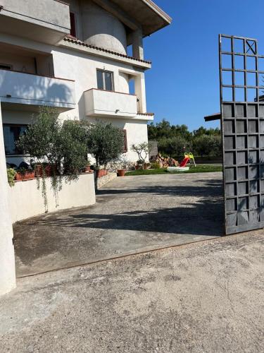 a building with a gate in front of a driveway at La Maison di Franca in Riace Marina