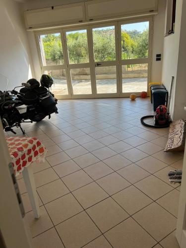 a living room with a tiled floor and windows at La Maison di Franca in Riace Marina