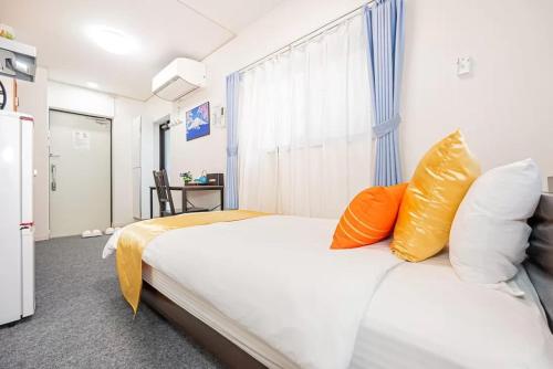 a bedroom with a bed with orange and white pillows at Akihabara Skytree Premium Apartment 201 in Tokyo