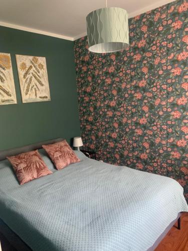a bedroom with a bed with a floral wallpaper at Apartament dwupokojowy in Gollnow