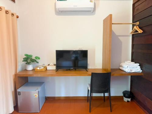 a room with a desk with a television and a chair at Green Haven Villas With Jacuzzi in Krabi town