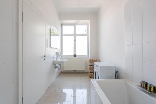 a bathroom with a tub and a sink and a window at Vienna Stay Apartments Schönbrunn in Vienna