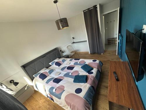 a bedroom with a bed and a wooden table at T2 moderne proche centre avec balcon et wifi in Saint Lo