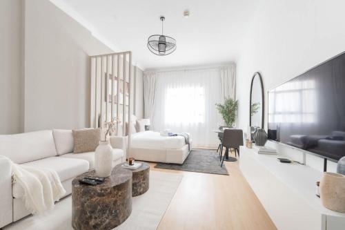 a white living room with a couch and a table at Free housekeeping visits during your stay - StayShort - JVC apartment for 2 people with Swimming Pool in Dubai