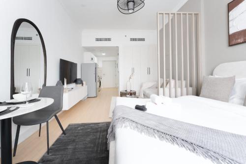 a white bedroom with a desk and a bed at Free housekeeping visits during your stay - StayShort - JVC apartment for 2 people with Swimming Pool in Dubai