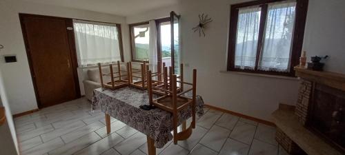 a living room with a table and chairs and windows at Appartamento Vecchio Sentiero in Frontignano di Ussita