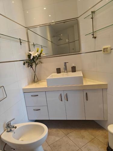 a bathroom with a sink and a toilet and a mirror at Migdal Luxury Suites - Sea Dream in Netanya