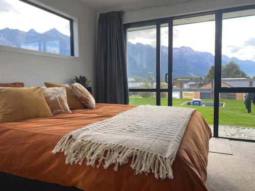 a bedroom with a bed with a view of mountains at House in central Glenorchy in Glenorchy
