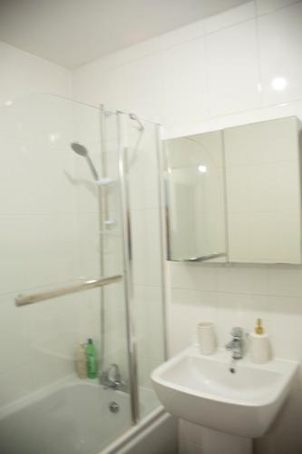 a white bathroom with a sink and a shower at Spacious home for construction workers and families with parking spaces 2 and half bathroom& ensuite Free wifi in Ashford