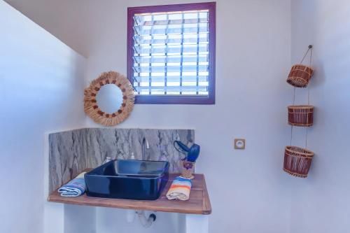 a bathroom sink on a shelf with a window at Ambaro Paradise Villa in Ambaro