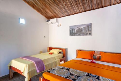 a bedroom with two beds and a bench in it at Ambaro Paradise Villa in Ambaro