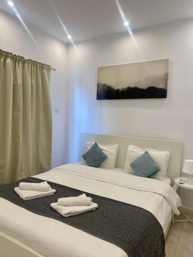 a bedroom with a large bed with towels on it at 1-bedroom duplex 100m by the sea in Limassol