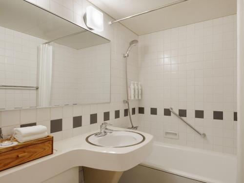 a white bathroom with a sink and a mirror at Fairfield by Marriott Sapporo in Sapporo