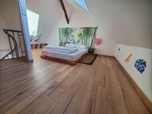 a bedroom with a bed and a wooden floor at Ludo'gîte 