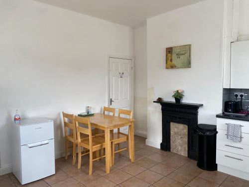 eine Küche mit Tisch und Stühlen und einem Kamin in der Unterkunft Hilltop Cottage in Renishaw