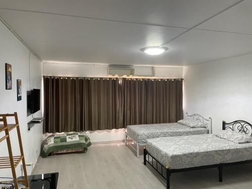 a room with two beds and a window with curtains at Dailyroom C3,C4by Anna in Nonthaburi