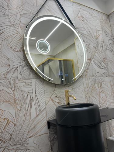 a bathroom with a round mirror and a sink at Omero in Reggio di Calabria