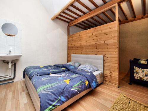 a bedroom with a bed with a wooden wall at Holiday Home in Rendeux with Terrace in Rendeux