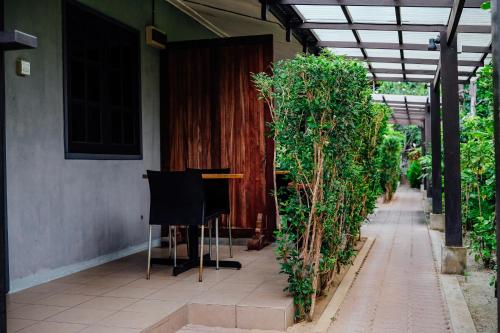 a room with a table and chairs next to a building at Tropical Langkawi in Pantai Cenang