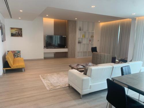 a living room with a white couch and a table at Luxe Private Beach Apartment Residence in Sharjah