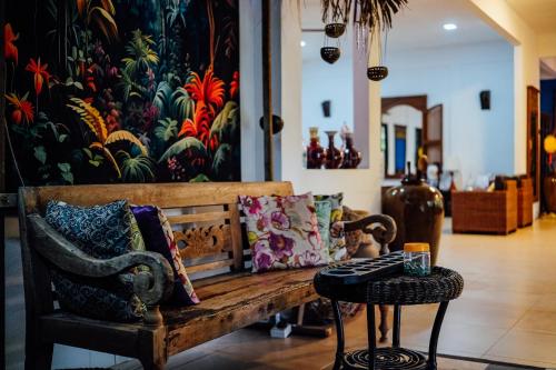 a bench with pillows and a table in a room at Tropical Langkawi in Pantai Cenang