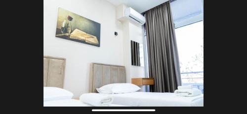 a hotel room with two beds and a window at Brusiano in Vlorë