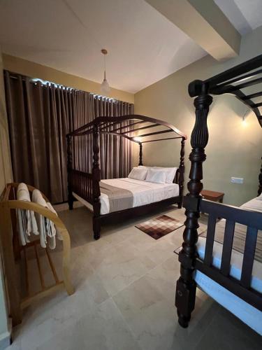 a bedroom with two beds and a canopy bed at Ella Family House in Ella