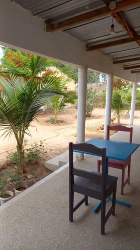 Una mesa azul y un banco debajo de un porche. en Villa Ndangane, en Ndangane