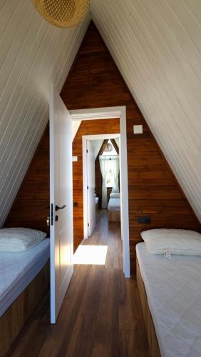 a attic bedroom with two beds and an open door at B&B Cottage in Mestia in Mestia