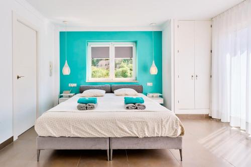 ein Schlafzimmer mit einem großen Bett mit einer blauen Wand in der Unterkunft Gr03 Casa La Buena Vida Torrox in Torrox