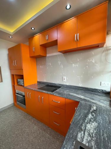 a kitchen with orange cabinets and a counter top at Zuma Teal in Lagos