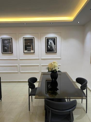 a dining room with a table with a vase of flowers at Zuma Teal in Lagos
