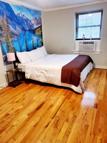a bedroom with a bed with a painting on the wall at Entire Apartment in heart of Lincoln Park & Lake Sea and beach in Chicago