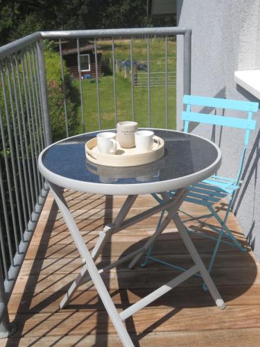 a table with two coffee cups and a blue chair at FerienLoft Eifeel Good - Natururlaub in Monschau in Monschau