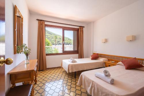 En eller flere senge i et værelse på Apartamentos Cala LLonga Playa
