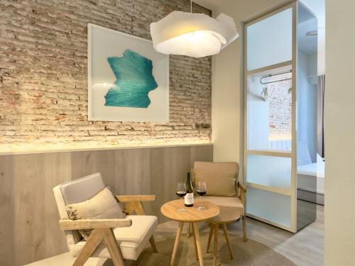 a living room with a table and chairs and a lamp at Coeo Frailes Design Apartments in Málaga