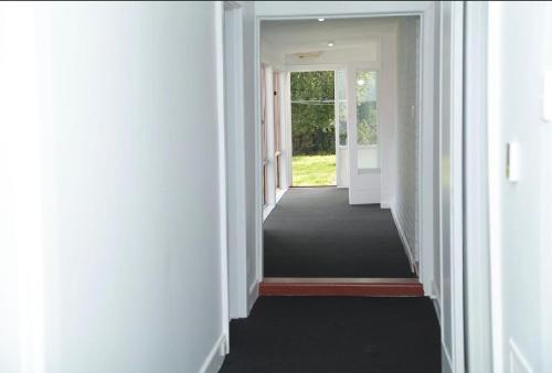 a hallway with white walls and a black carpet at Engelhardt Guest House in Melbourne