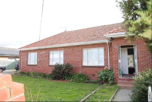 a red brick house with its door open at Engelhardt Guest House in Melbourne