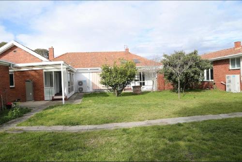 a house with a grass yard in front of it at Engelhardt Guest House in Melbourne