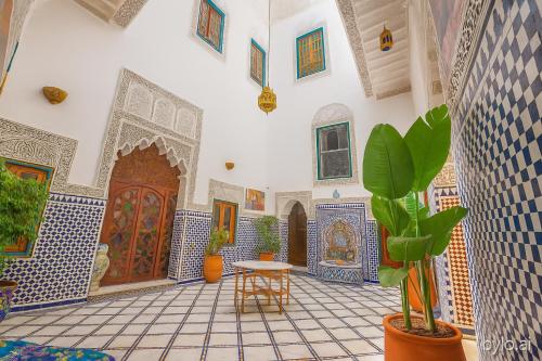 a room with blue and white tiled walls and a table with plants at Riad Rayhana-Exclusive Riad Experience in Fes Medina in Fès